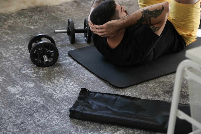 Man doing barbell exercises on gym mat - strength training and gym workouts for beginners